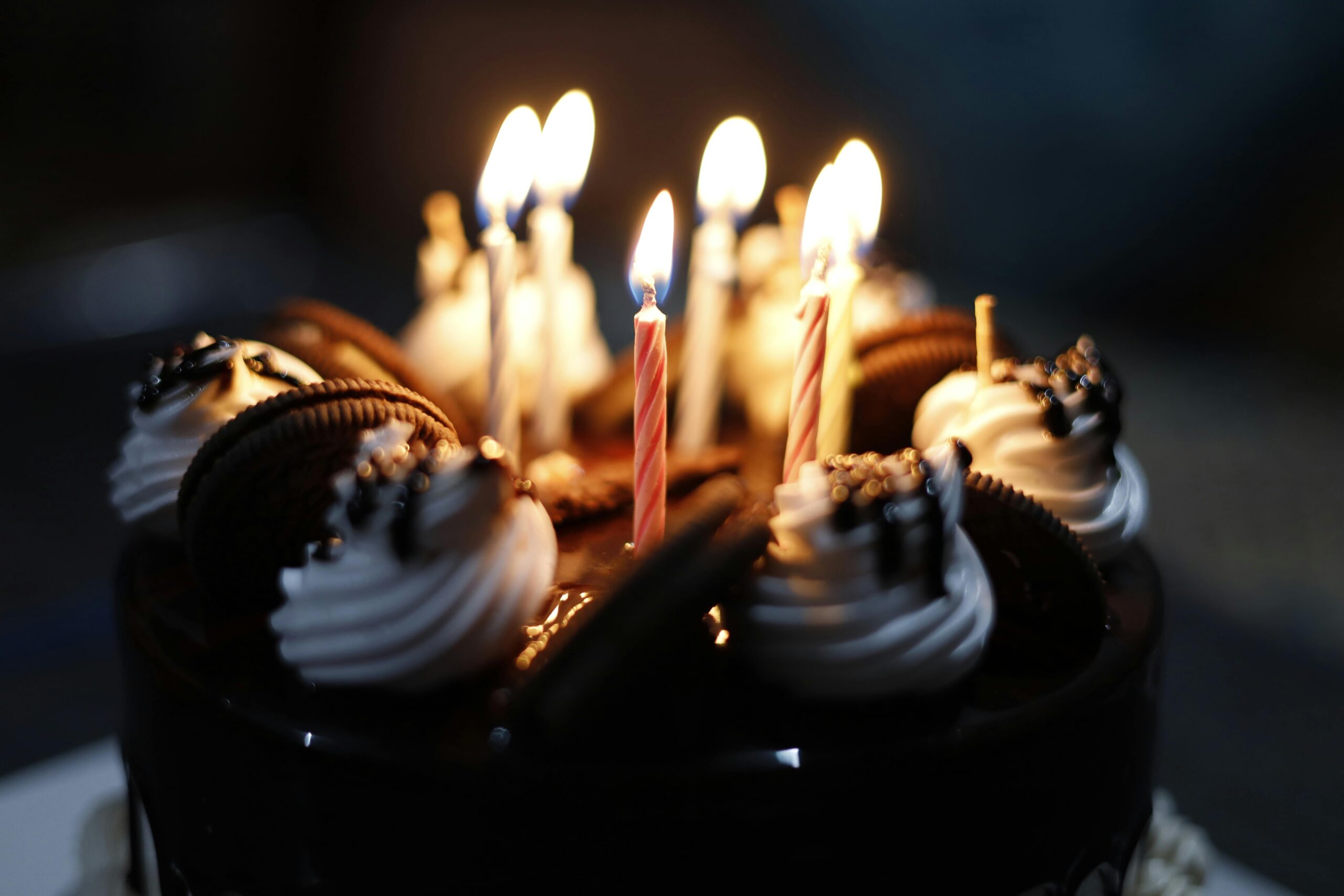 Close-up of a chocolate cake with candles and cookies, perfect for celebrations.