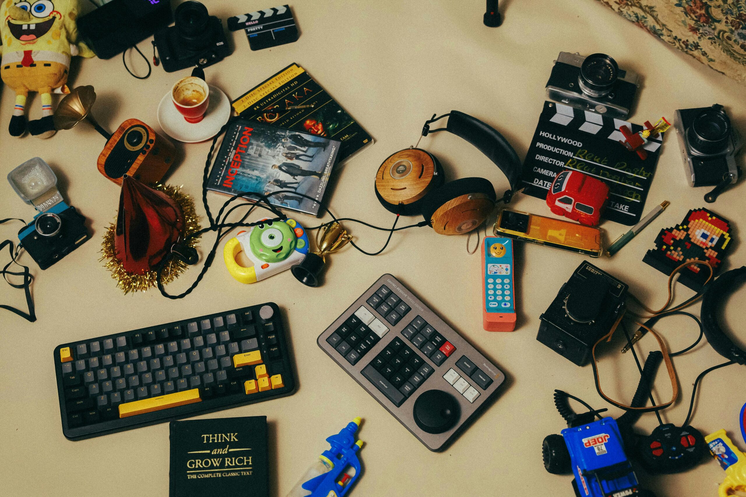 A flat lay of gadgets, toys, and creative tools in a workspace, perfect for creative editing projects.